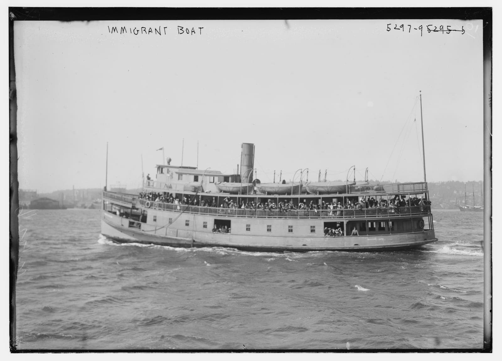Crowded immigrant ferry carrying new arrivals across New York Harbor around 1900